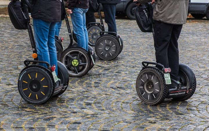 Fünf Segway-Fahrer unterwegs auf Kopfsteinpflaster